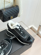Chanel ladies sneakers on a gray box, black with white sole edges