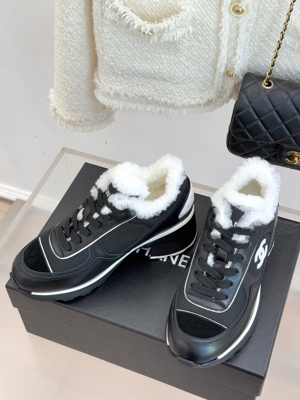 Pair of Chanel ladies sneakers on a box, black uppers with white trim