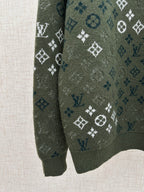 Dark green knit sweater sleeve with all-over logo pattern and ribbed cuff