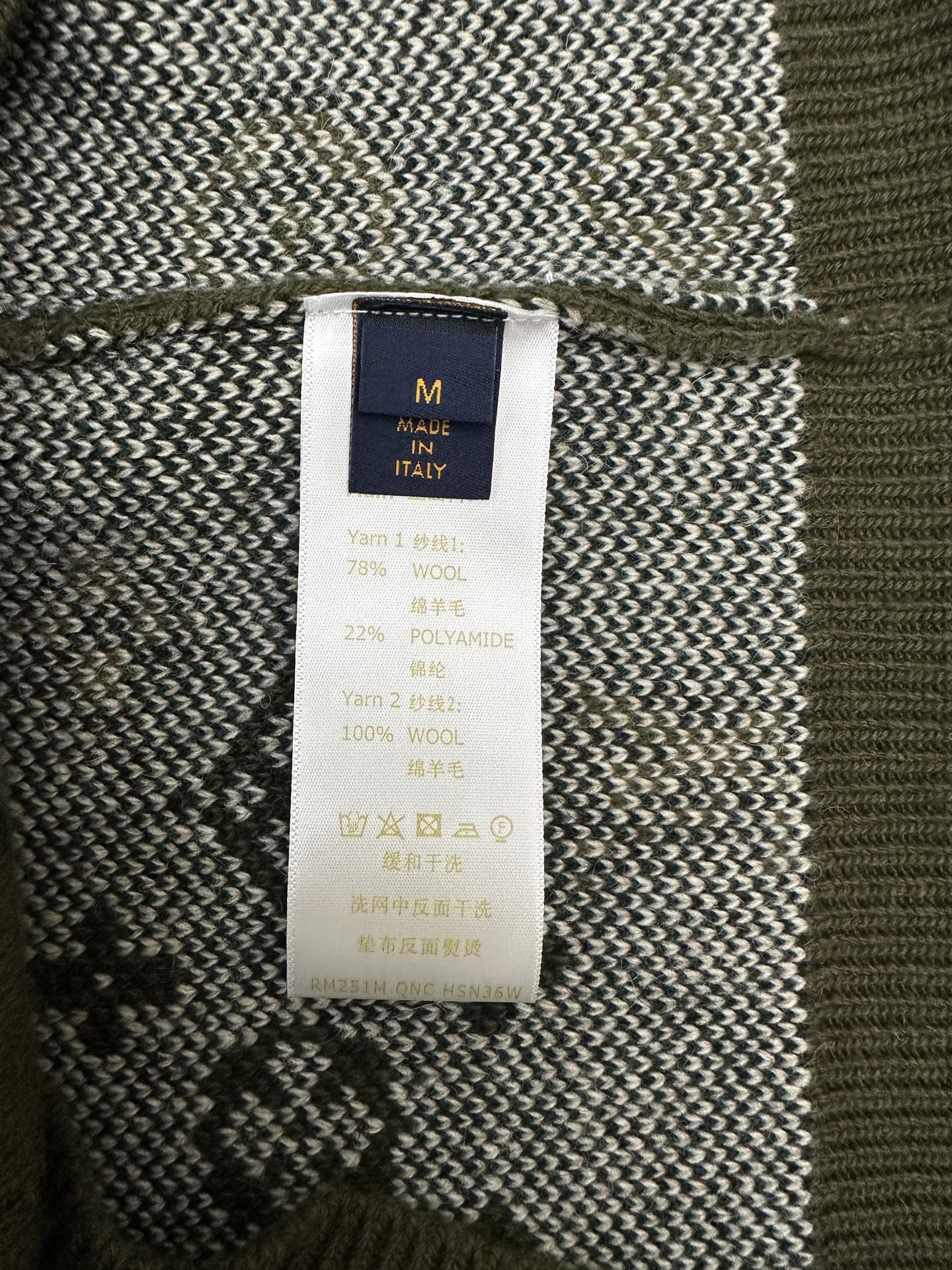 Inside neck label on green knit sweater with material percentages and Made in Italy