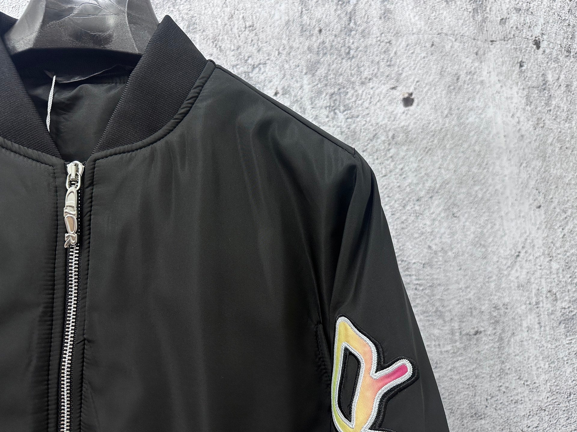 Dior black bomber jacket sleeve patch with logo graphic, zip edge detail