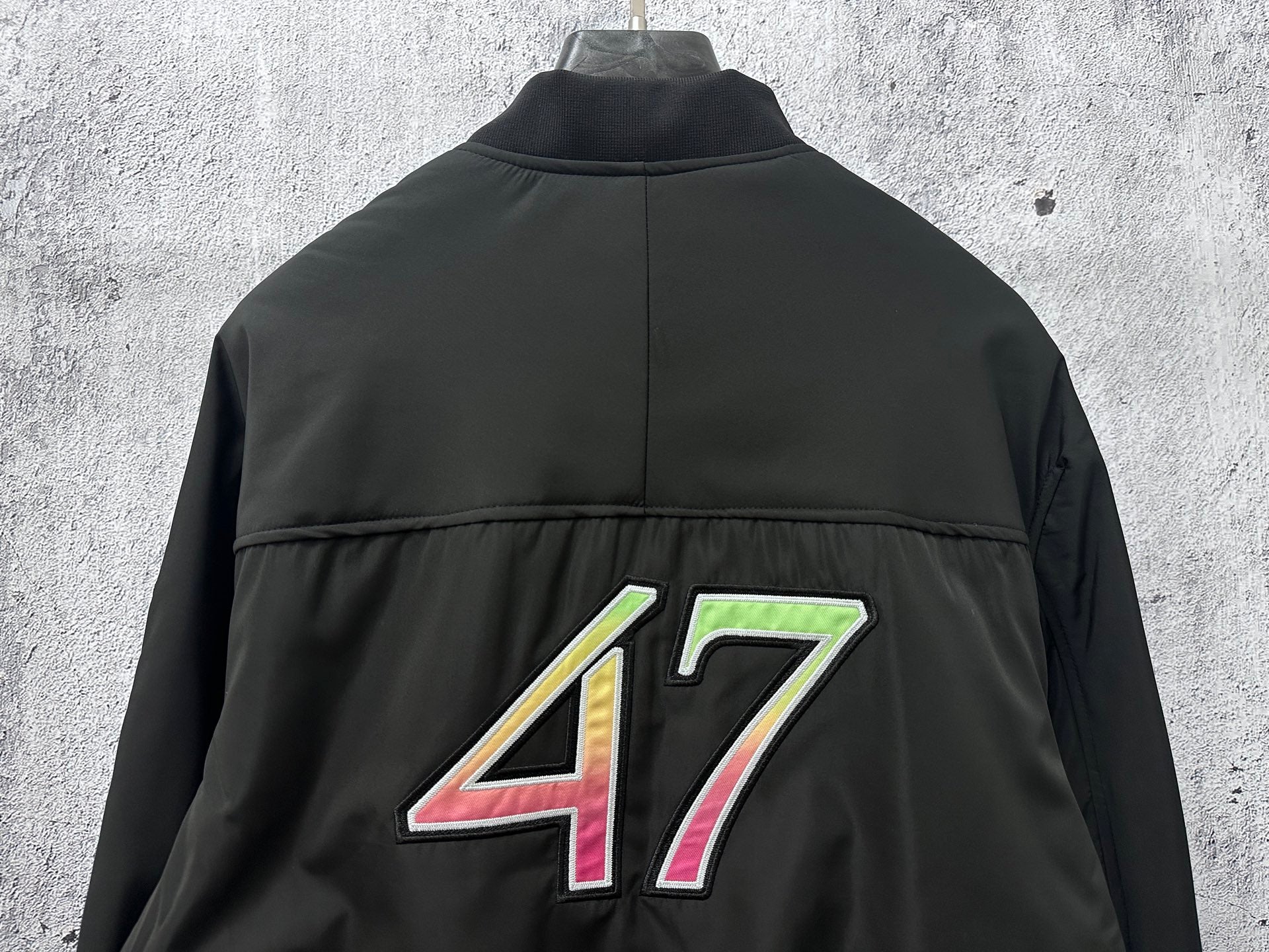 Dior black bomber jacket back view with large 47 graphic centered