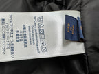 Jacket care label with fabric instructions and brand tag attached inside collar