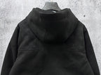Dark hooded jacket back view with monogram shoulder panels and gathered hem