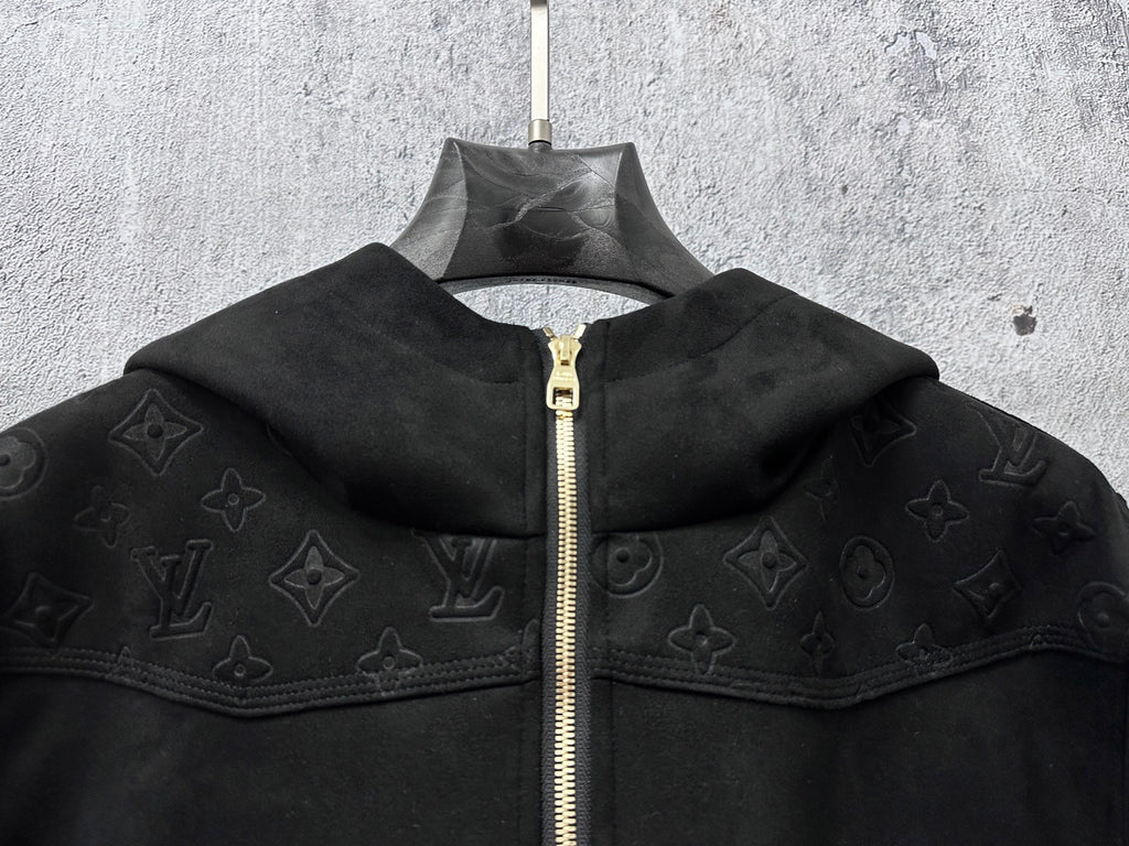 Dark hooded zip jacket close-up showing wide collar and gold zipper
