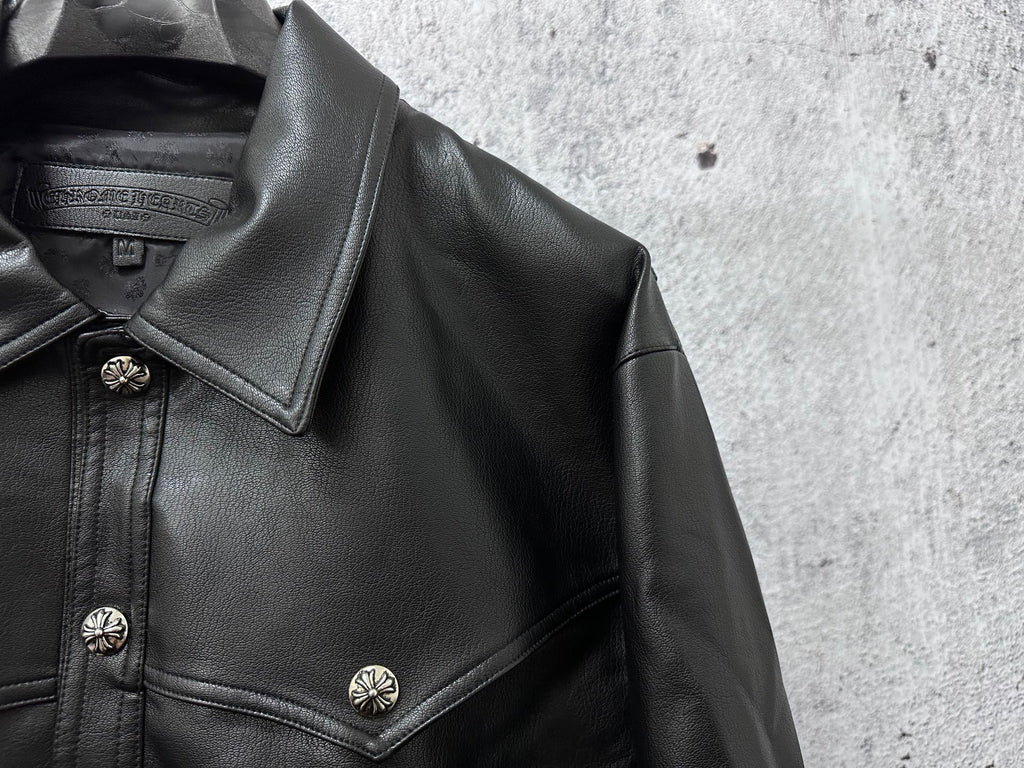 Close-up of dark leather jacket collar and shoulder with decorative snap buttons.