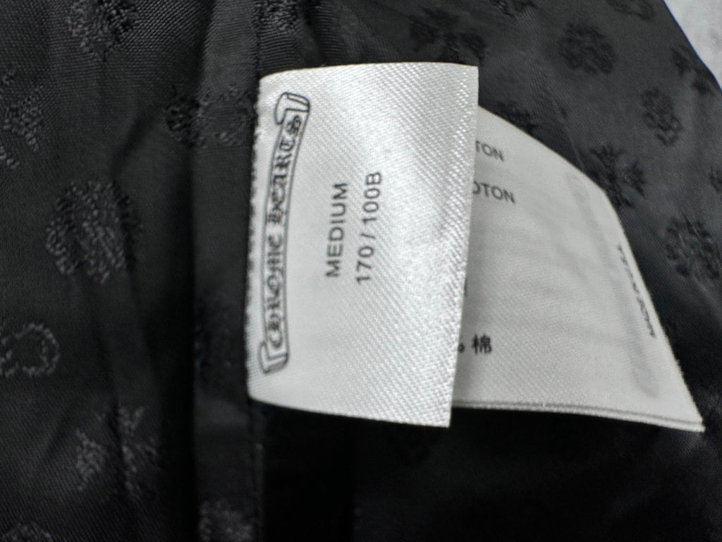 Clothing label inside dark leather jacket, shows size medium and fabric type.