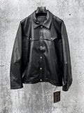 Dark leather jacket with spread collar, button front, and chest flap pockets.