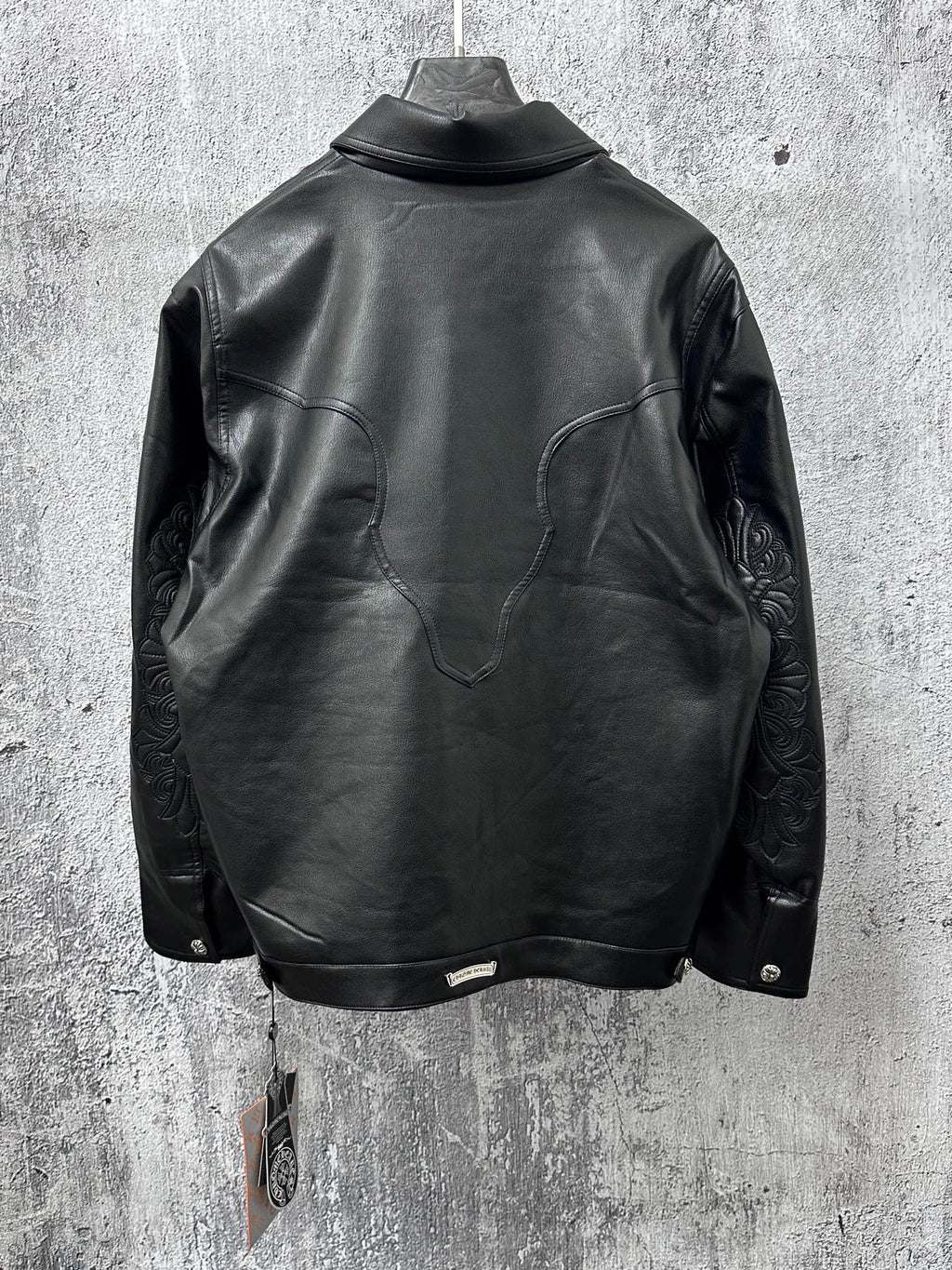 Dark leather jacket back view with curved yoke and long sleeves.