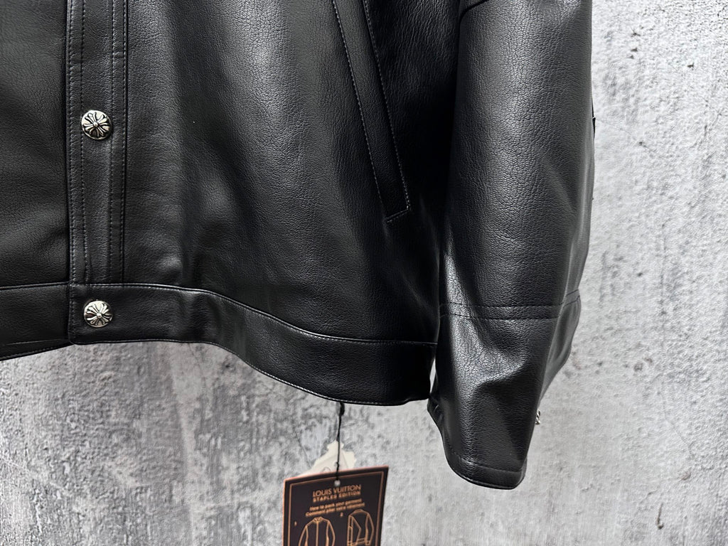 Dark leather jacket sleeve and shoulder with snap detail at cuff.