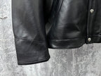 Dark leather jacket lower front with side seam paneling and buttoned detail.
