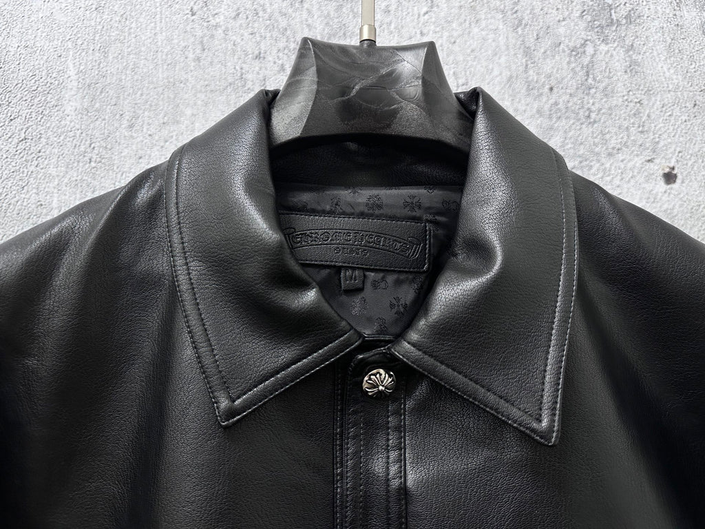 Dark leather jacket neckline with spread collar and central snap placket.