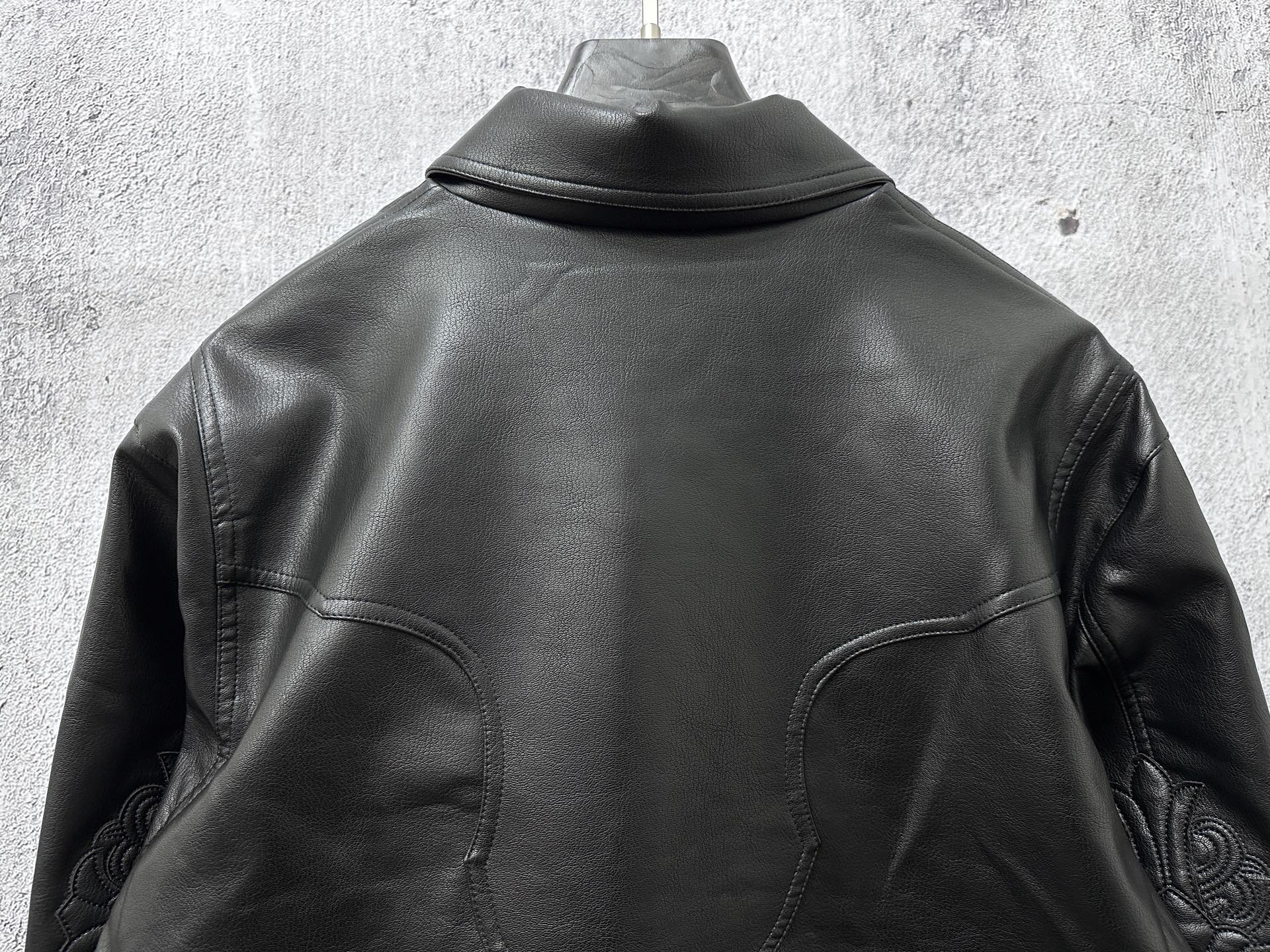Dark leather jacket back view with high collar and curved seam panels.