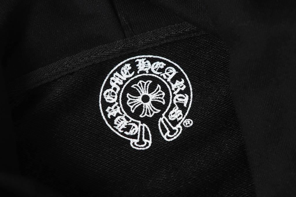 Black hoodie fabric close-up with small circular white logo