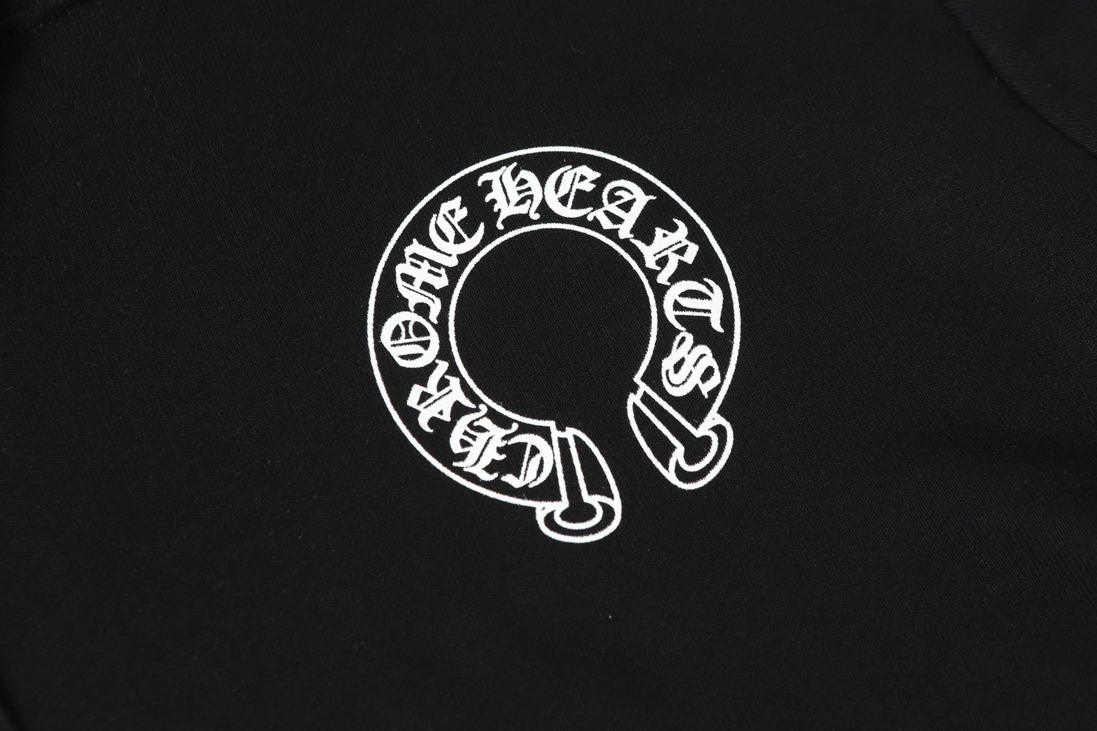 Black hoodie chest area with large circular white logo print