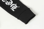 Black long-sleeve hoodie sleeve cuff with white graphic emblem