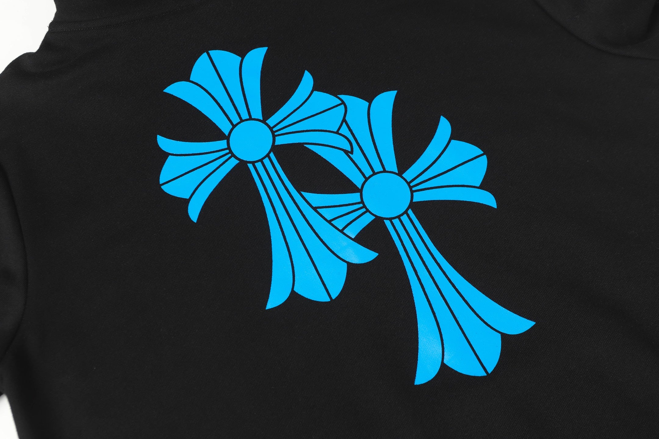 Blue flower graphic print on black hoodie close-up