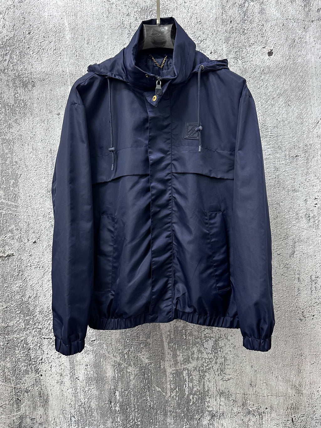 Long hooded jacket with full zipper and front pockets, dark navy blue.