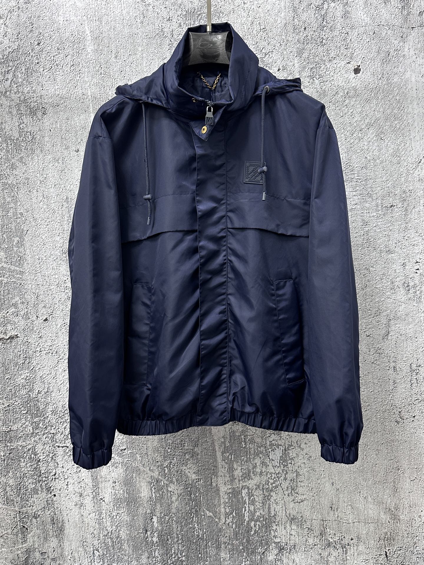 Long hooded jacket with full zipper and front pockets, dark navy blue.