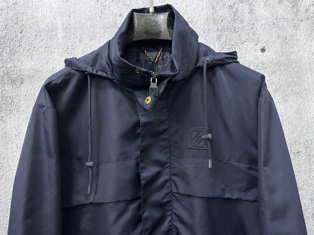 Long hooded jacket front view with drawstring hood and chest patch pockets, navy.