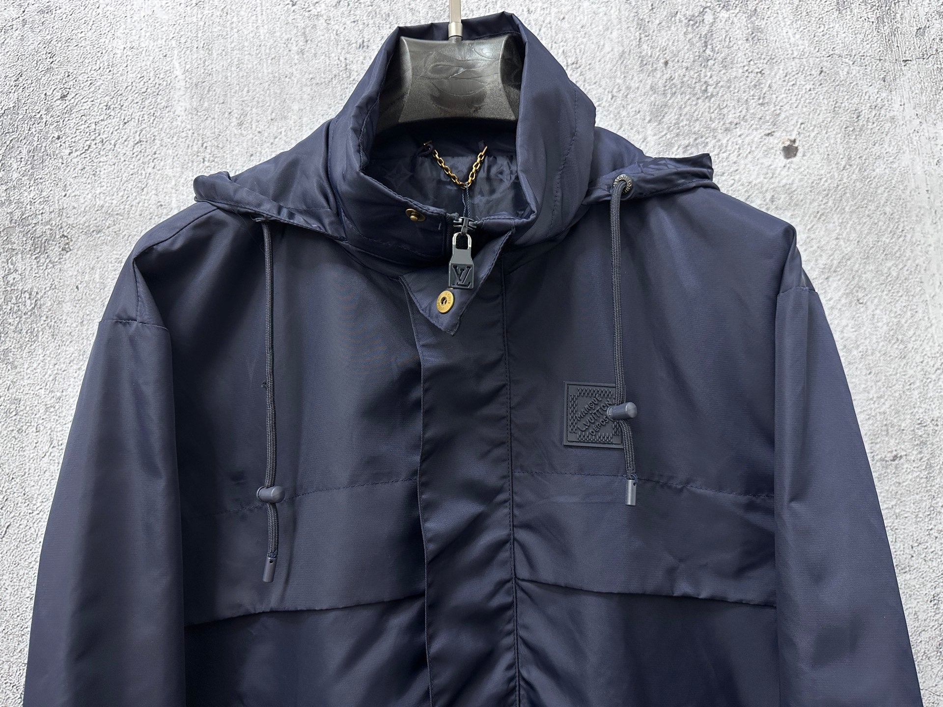 Long hooded jacket front view with drawstring hood and chest patch pockets, navy.