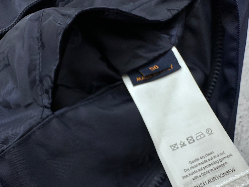 Louis Vuitton garment tag label inside long hooded jacket, dark navy fabric.
