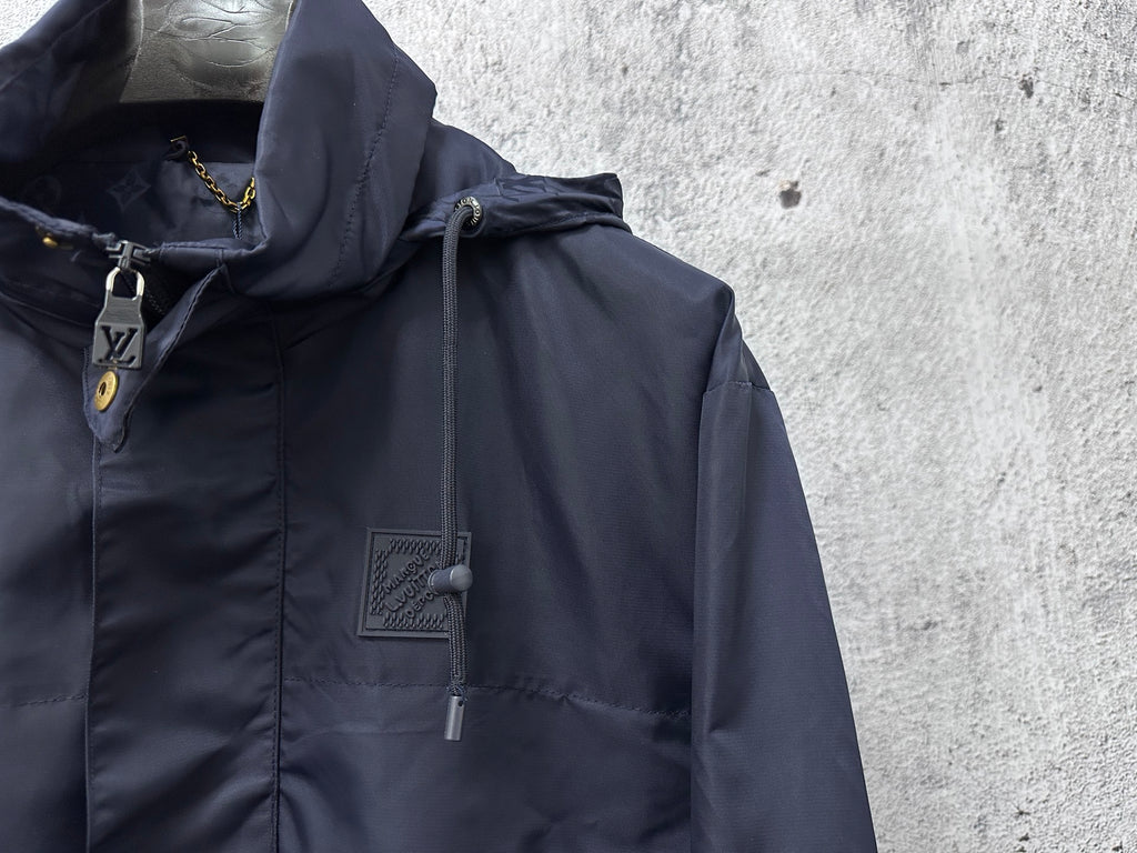 Hooded jacket close-up showing drawstring hood and zipper with dark navy fabric.