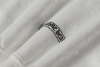 White zip-up hoodie sleeve with small embroidered crest label