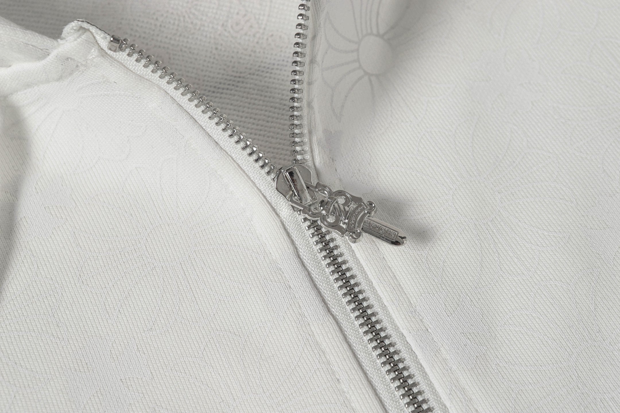 Chrome long hoodie front zipper close-up with metal teeth and top stop