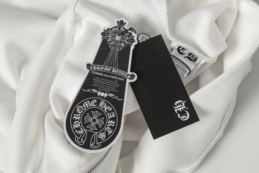 White zip-up hoodie with printed sleeve crest patch and black care tag