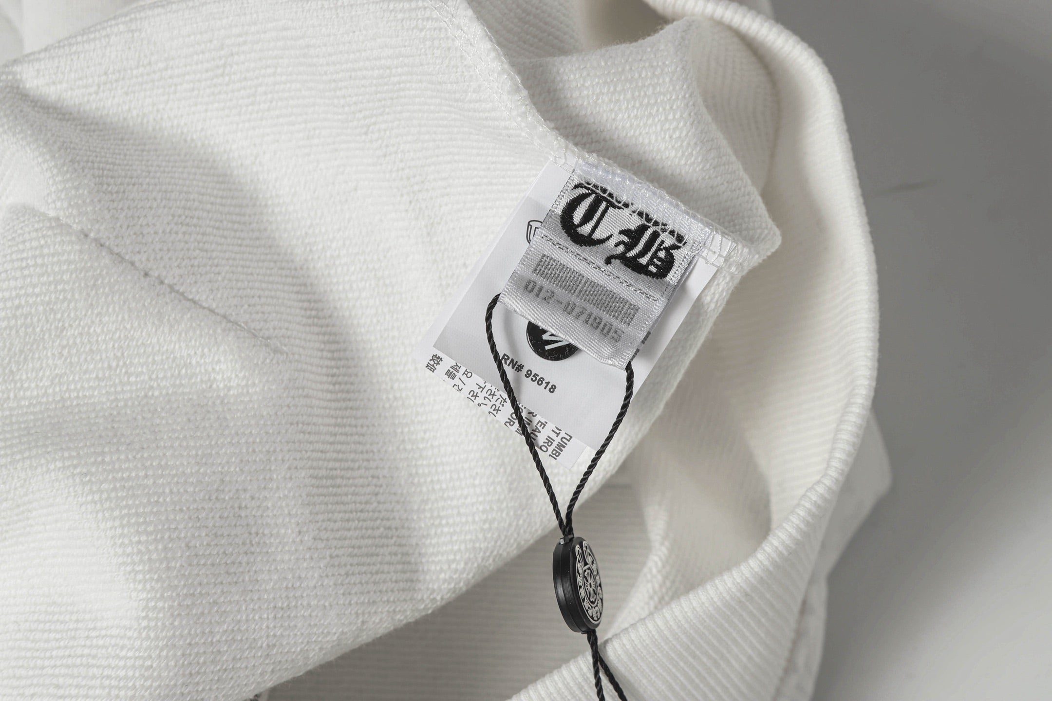 Chrome long hoodie neck label and hanging tag close-up