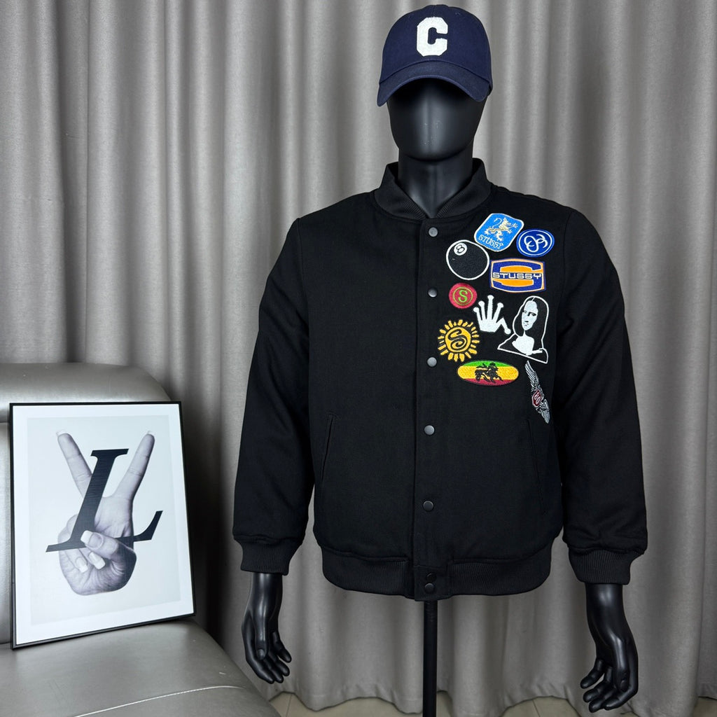 Black button-front bomber jacket on mannequin, colorful chest patches