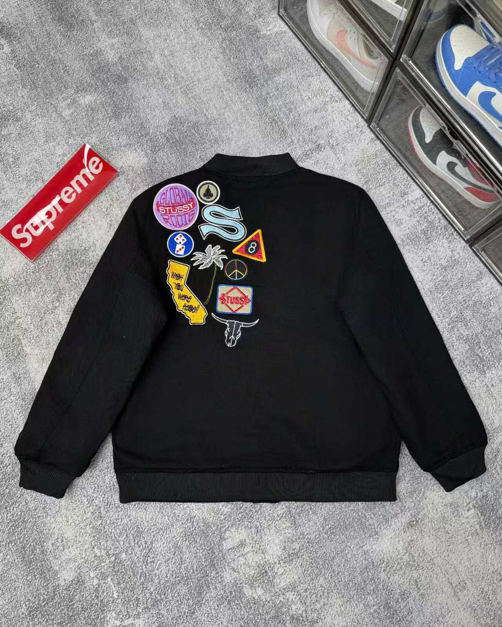 Black jacket back with multicolor patches and circular logo emblems