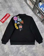 Black jacket back with multicolor patches and circular logo emblems