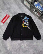 Black button-front jacket with colorful patches on chest and ribbed cuffs