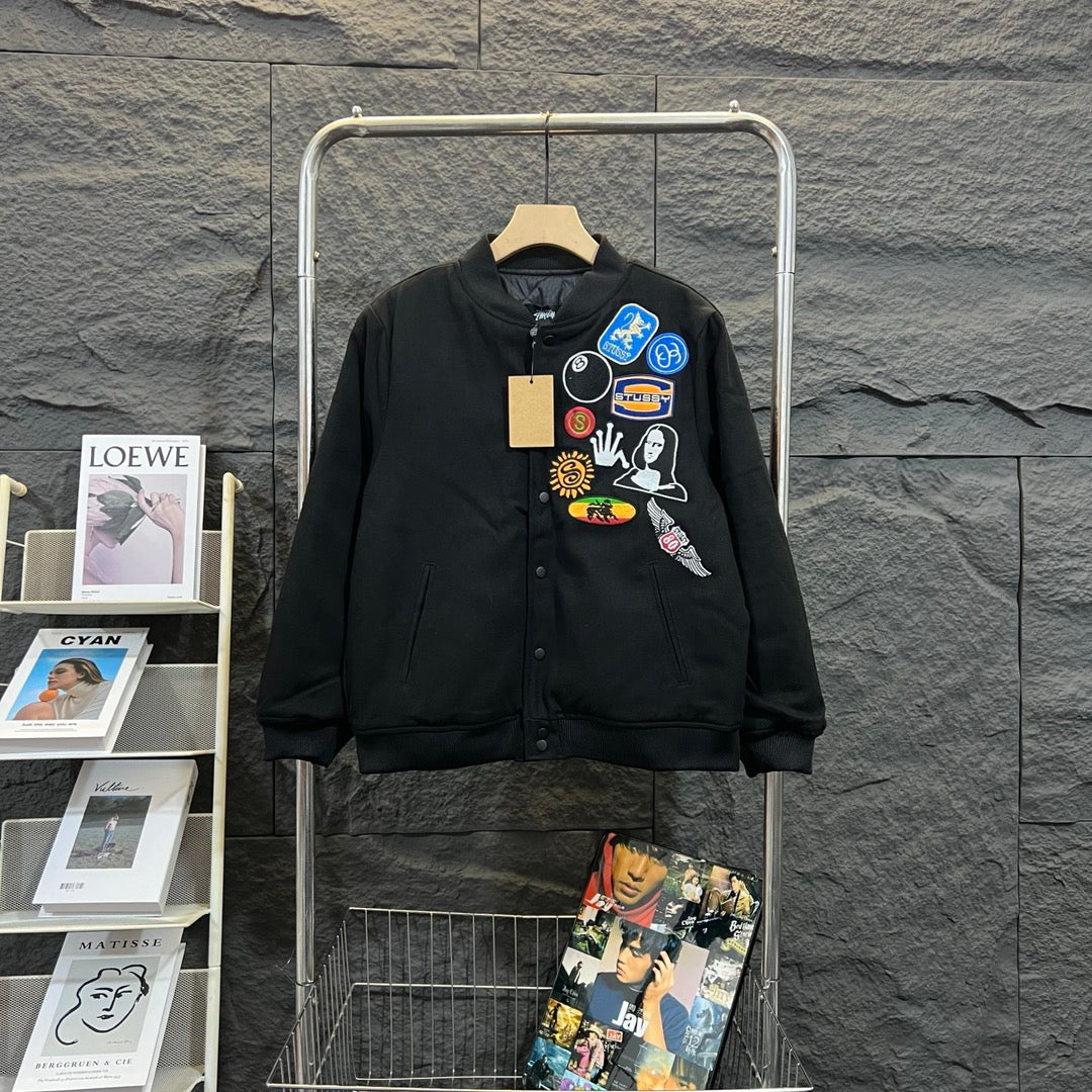 Stussy black bomber jacket, front with colorful patch collage and button placket