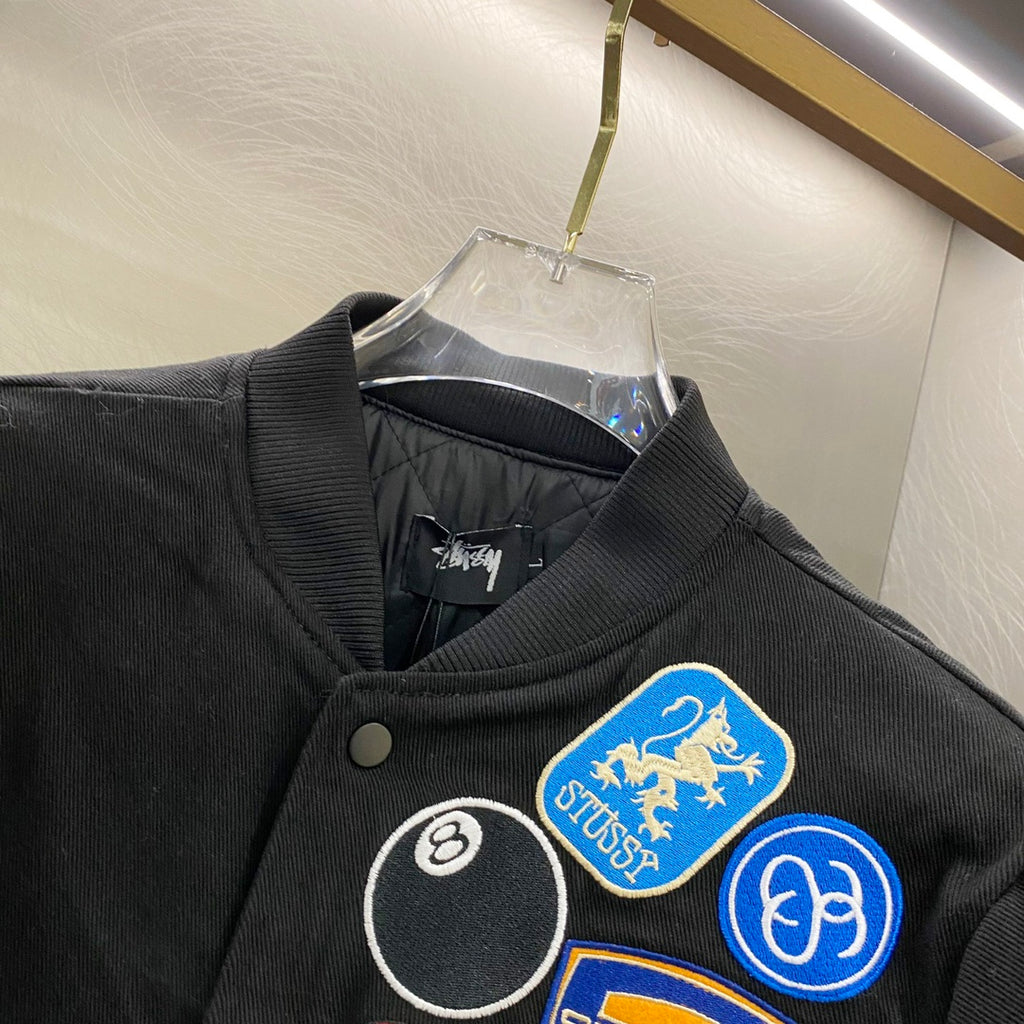 Black snap-front jacket collar with round and graphic patches