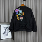Black bomber jacket back with multicolor graphic patches and stitched emblems
