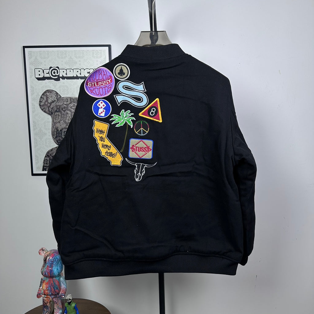 Black Stussy bomber jacket with large multicolor back patch graphic