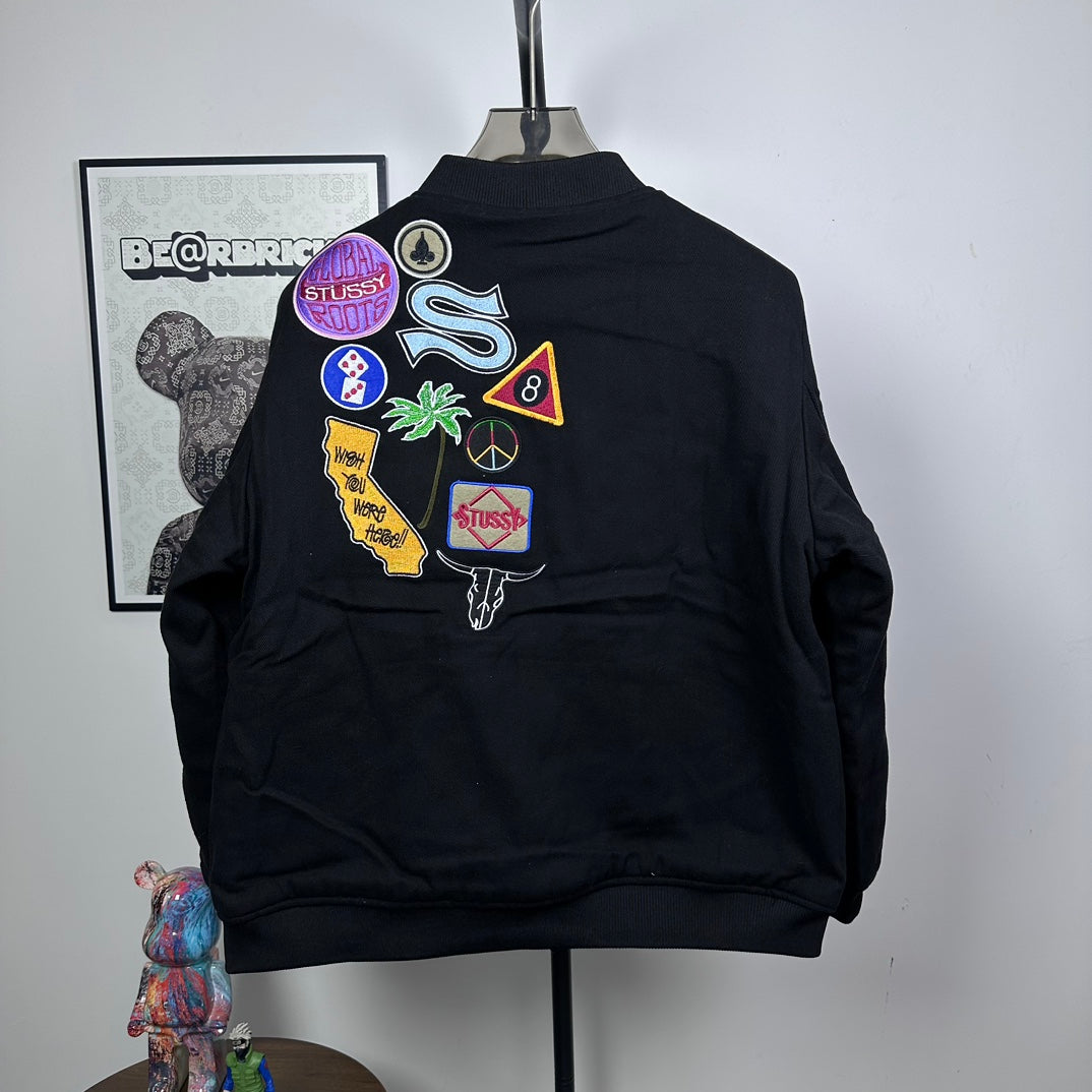 Black Stussy bomber jacket with large multicolor back patch graphic