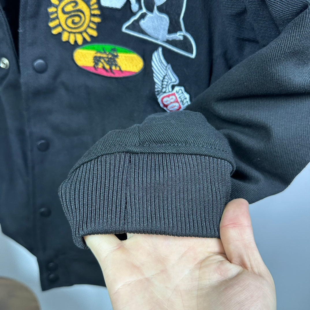 Black bomber jacket ribbed cuff with colorful embroidered patch on sleeve