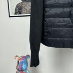 Moncler long puffer jacket side view with dark knit sleeve and quilted hem