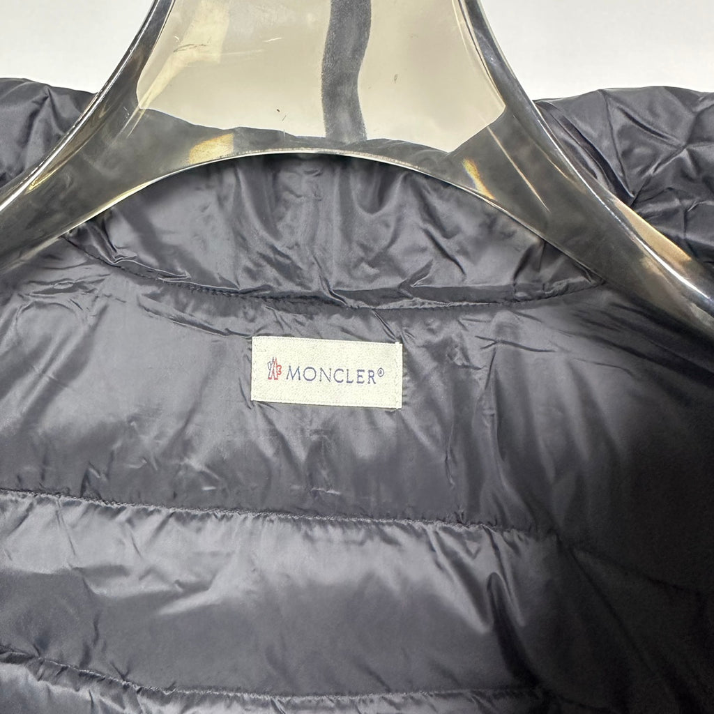 Moncler long puffer jacket with quilted dark shell and brand label at chest
