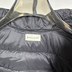 Moncler long puffer jacket with quilted dark shell and brand label at chest