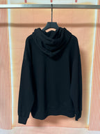 Dark hoodie with hood and front kangaroo pocket, worn on hanger