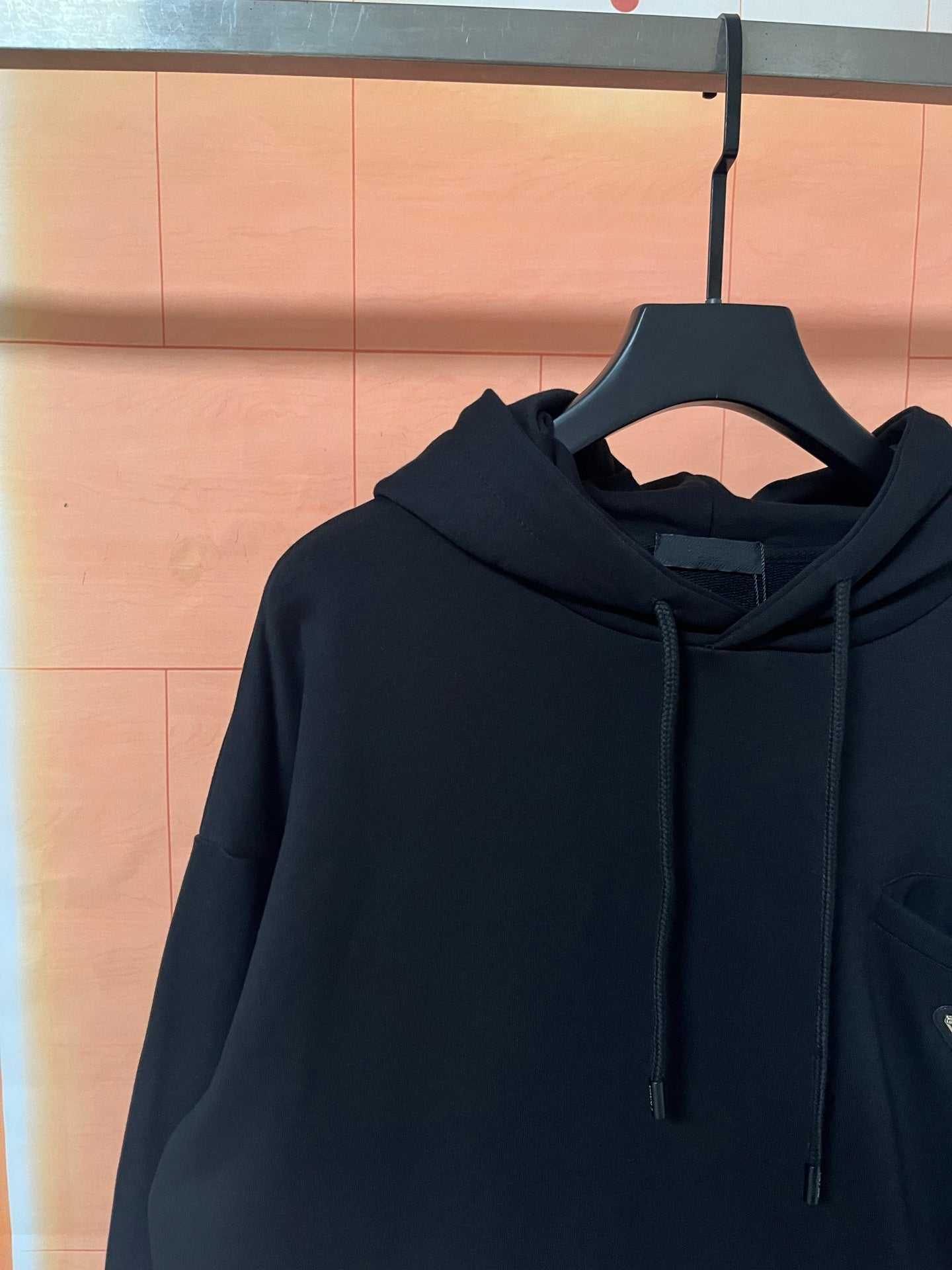 Dark Prada hoodie with hood and drawstrings, side view on hanger