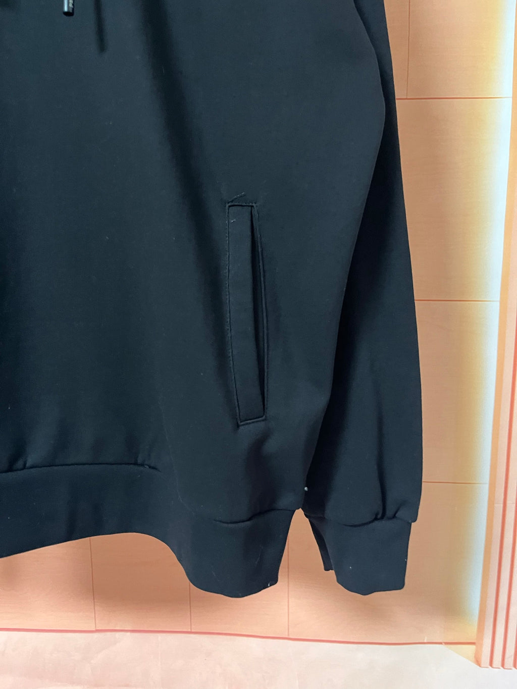 Dark hoodie lower front with pocket opening and hem
