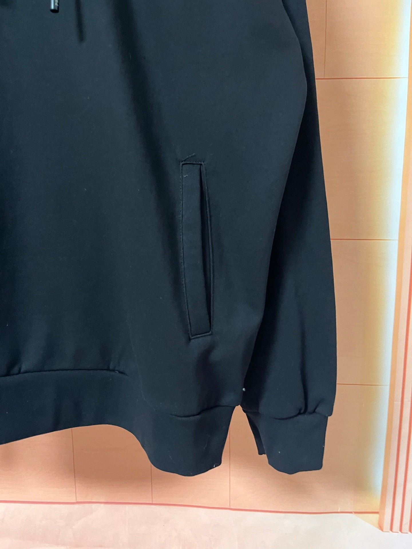 Dark hoodie lower front with pocket opening and hem