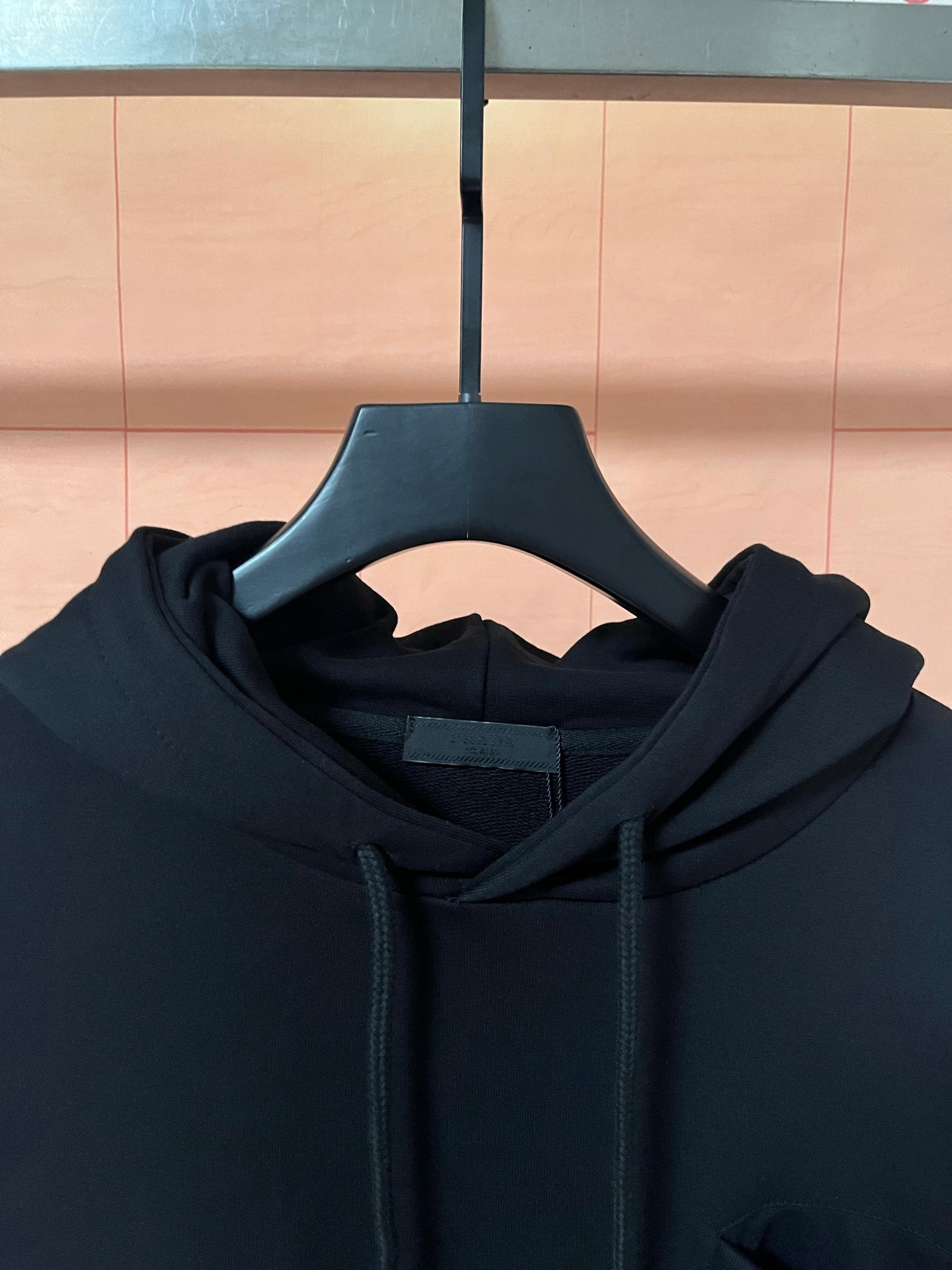 Dark hoodie hood neckline close-up with drawstrings and inner hood