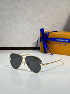 Louis Vuitton sunglasses with black tinted lenses and gold-tone metal frames